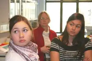 Agathe Møller og Kista Høegh (til højre) lytter intenst, under rundvisningen i et af forskningslaboratorierne på GEUS. Deres lærer Hanne Frederiksen ses i midten.