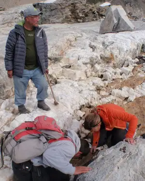 Geologerne undersøger stenen og William står ved siden af