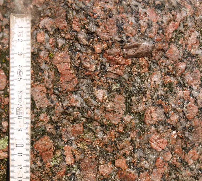 Gubstenen består af grovkornet granit, hvor kalifeldspat er altdominerende